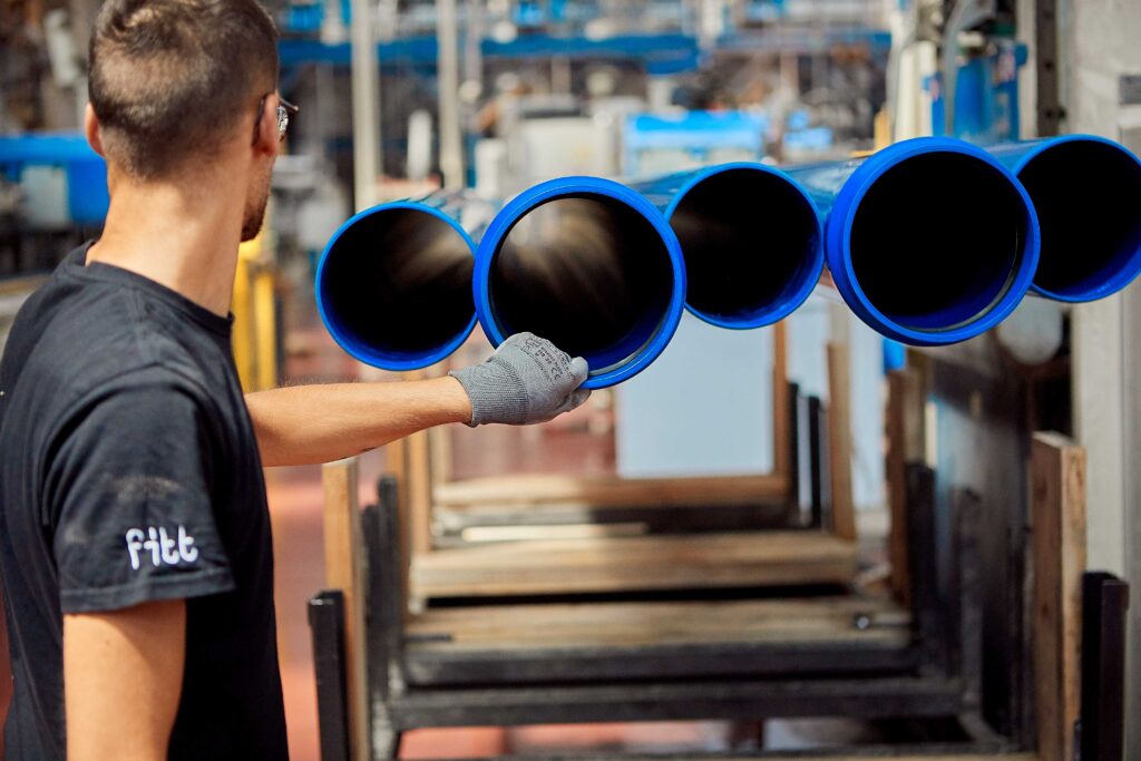 immagine di uomo al lavoro con tubi blu
